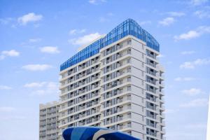 a tall white building with a blue roof at Yangyang Cohost Studio in Yangyang