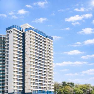 a tall white apartment building with blue windows at Yangyang Cohost Studio in Yangyang