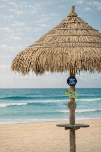 a straw umbrella on a beach with the ocean at Yangyang Cohost Studio in Yangyang +7 photos