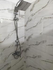 a shower in a bathroom with white marble walls at Toscana Apartamentos in Progreso +35 photos