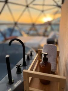a bathroom sink with a soap dispenser and a towel at Bubble Sky Villas Kosove in Ferizaj