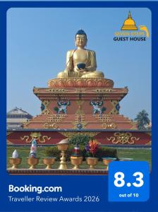 a large golden statue sitting on top at Seven Steps Guest House in Rummindei