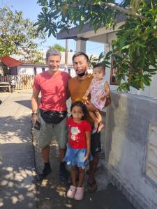 two men and a child posing for a picture at Sherin Homestay in Pulau Sarang