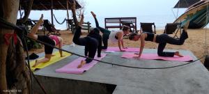 a group of women doing yoga on the beach at Ocean & Beach kite Hotel in Kalpitiya