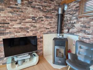 a living room with a television and a fireplace at Yangpyeong Mulsori Supbaram in Yangpyeong