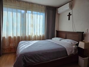 a bedroom with a bed with a cross on the wall at Yangpyeong Mulsori Supbaram in Yangpyeong