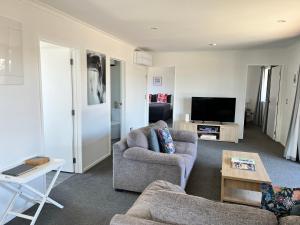 a living room with two couches and a television at Mountain views on Mackenzie in Twizel