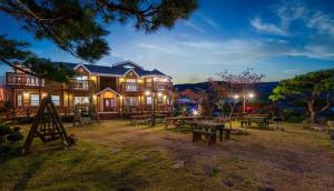 a large house with picnic tables in front of it at Buan Pension Maple in Buan