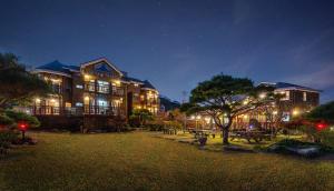 a large building with a park at night at Buan Pension Maple in Buan +11 photos