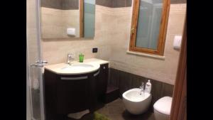 uma casa de banho com um lavatório, um WC e um espelho. em La Suite em SantʼAlessio Siculo