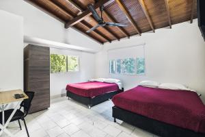 a bedroom with two beds and a table and windows at Living Hotel in Medellín