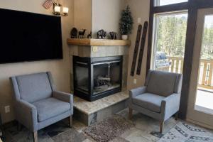 a living room with two chairs and a fireplace at Kirkwood Mountainside Cabin & Cottage Deck wViews in Kirkwood