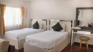 a bedroom with two beds and a desk with a mirror at Natural Place in Ban Khan Ham +23 photos