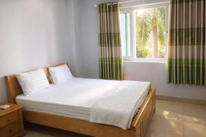 a bedroom with a large bed with a window at M&M Việt Tiệp Hotel in Dĩ An