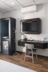 a desk with a tv and a chair in a room at M&M Việt Tiệp Hotel in Dĩ An +41 photos