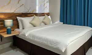 a bed with white sheets and pillows on it at Perth City Motel in Perth