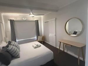 a hotel room with a bed and a mirror at Units on Robertson in Mudgee