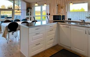 a kitchen with white cabinets and a sink and a table at Amazing Home In Tarm With Sauna in Tarm +26 photos