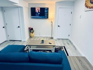 a living room with a blue couch and a table at Maple Nest in Regina