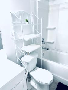 a white bathroom with a toilet and a sink at Maple Nest in Regina +16 photos
