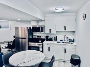a kitchen with white cabinets and a table and chairs at Maple Nest in Regina