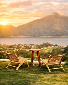 two chairs and a table on top of a field at Glamor Kintamani in Kubupenlokan