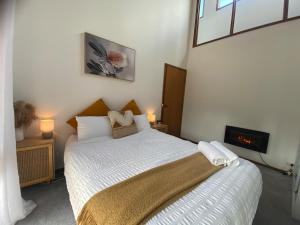 a small bedroom with a bed with a white bedspread at Riverlin Estate in Warburton +64 photos
