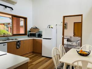 a kitchen with a table and a white refrigerator at Riverlin Estate in Warburton