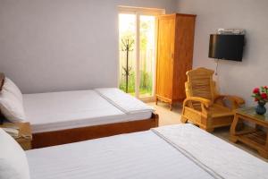 a hotel room with two beds and a television at M&M Việt Tiệp Hotel in Dĩ An