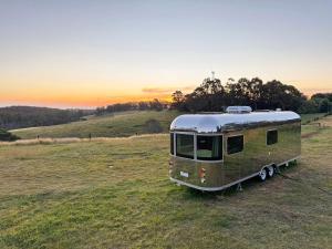 an old trailer parked in a field at sunset at One Life Glamping Caravan Rawson in Rawson