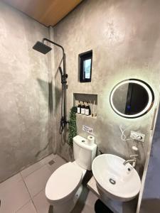 a bathroom with a white toilet and a sink at Astra Tourist Inn near Airport with high speed free Wifi in Puerto Princesa City