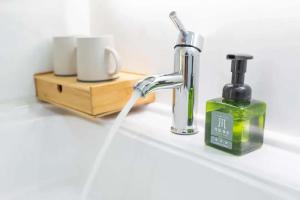 a bathroom sink with a faucet and a bottle of soap at TRANQUIL HOUSE in Lhasa +63 photos