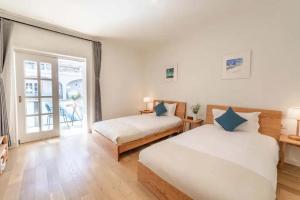 a bedroom with two beds and a balcony at TRANQUIL HOUSE in Lhasa