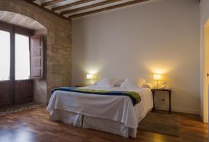 a white bedroom with a large bed and a window at La Capellanía in San Asensio