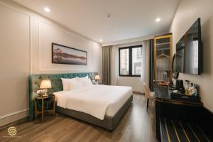 a hotel room with a bed and a television at San Hotel & Spa in Hanoi