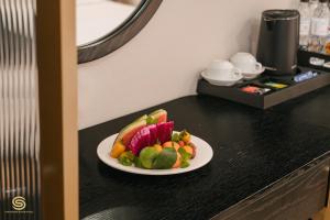 a plate of food on a counter with a plate of fruit at San Hotel & Spa in Hanoi