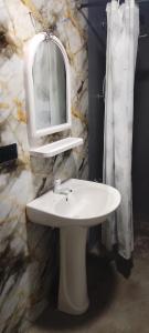 a bathroom with a white sink and a mirror at Pavis guest inn in Nallathanniya