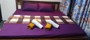 a bed with two pairs of towels on it at Pavis guest inn in Nallathanniya