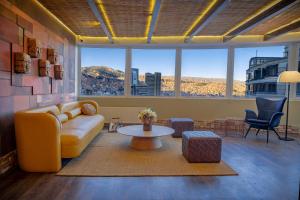 a living room with a yellow couch and a table at Illampu Art Boutique Hotel in La Paz