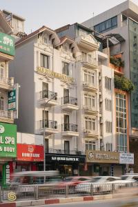 a tall white building on the side of a street at San Hotel & Spa in Hanoi