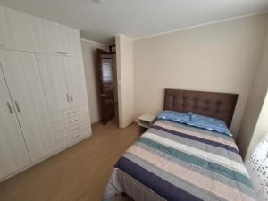 a bedroom with a bed and a white cabinet at Miski Wasi in Tacna