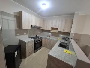 a kitchen with wooden cabinets and a stove top oven at Miski Wasi in Tacna