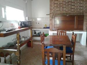 a kitchen with a wooden table and a dining room at Cedro Azul in Monte Hermoso