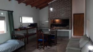 a living room with a fireplace and a table and chairs at Cedro Azul in Monte Hermoso