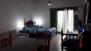 a bedroom with a bed and a living room with a couch at Cedro Azul in Monte Hermoso