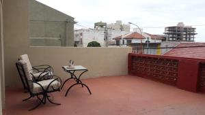 a patio with two chairs and a table on a balcony at Cedro Azul in Monte Hermoso