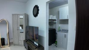 ein Wohnzimmer mit Fernseher und Wanduhr. in der Unterkunft Jacob's Place in Abu Dhabi