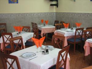 a dining room with tables and chairs with orange napkins at Hotel Nacional Melilla in Melilla