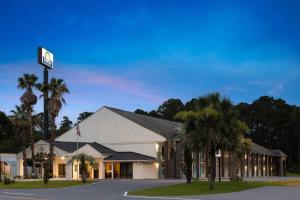 a hotel with palm trees in front of a building at Days Inn by Wyndham Hardeeville Near Hilton Head in Hardeeville