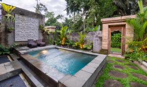 a swimming pool in a backyard with a garden at Jungle Forest Villa Ubud by The Travel Ubud Bali in Ubud